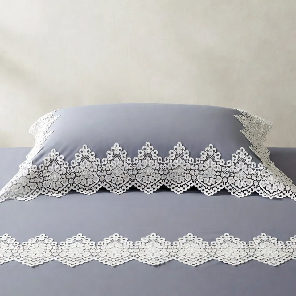 Light grey bed sheet with white lace borders for a minimalist look.
