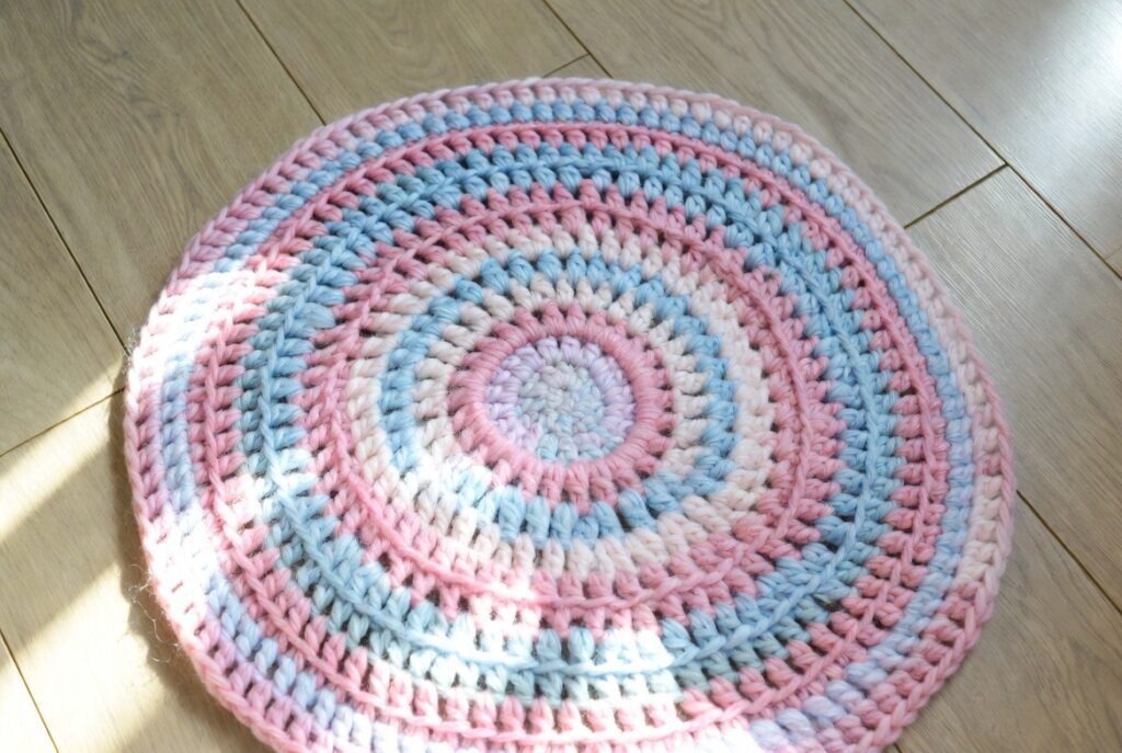 Round crochet blanket pattern worked from center outward with double crochet increases and decorative border.