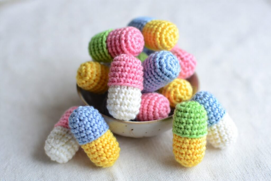 Colorful crochet amigurumi happy pills, small beginner-friendly crochet projects, perfect for gifts or décor.