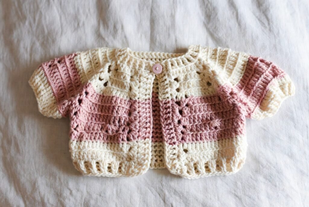 Soft pastel crochet baby sweater handmade for newborns.