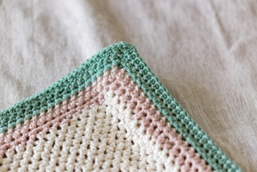 simple single crochet border around a moss stitch crochet blanket showing clean edging stitches